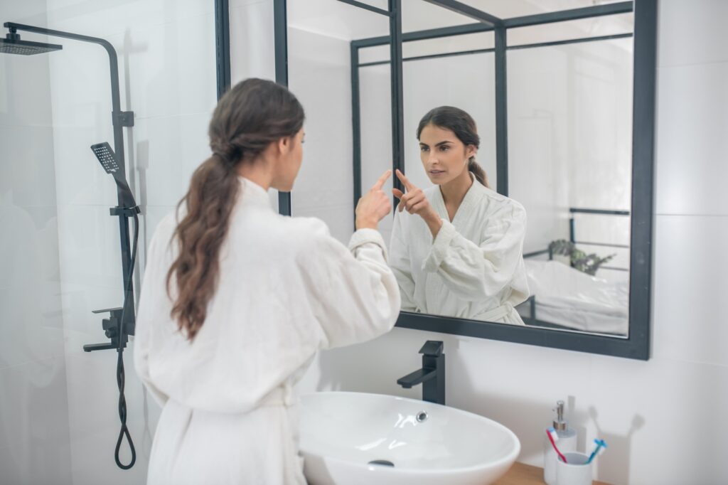 A picture of a young woman in a bathrobe in the bathroom