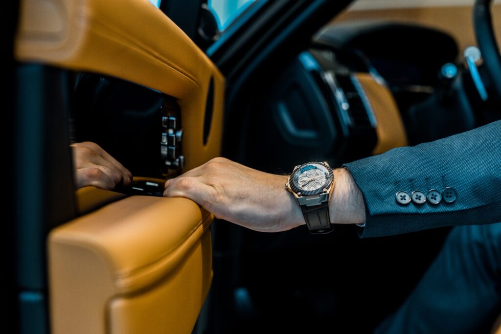 cropped image of businessman with luxury watch closing door while sitting in car